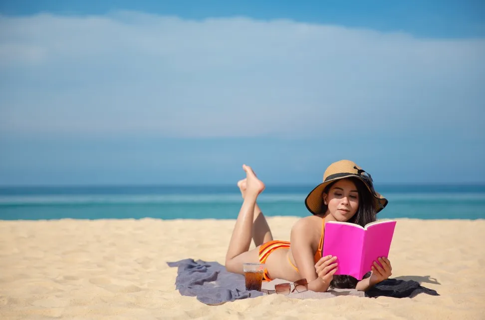 ビーチで本を読む女性